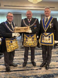 PGM of Gloucestershire presenting a wooden Travelling Sceptre to the MEGS of Gloucestershire and Herefordshire with the Provincial Grand Communications Officer of Gloucestershire